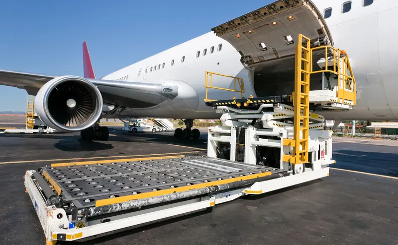 Freighter aircraft on stand with the main deck cargo door open and a scissor loader raised to the sill